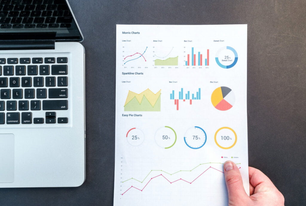 blad met verschillende statistieken en analyses op tafel bij de laptop