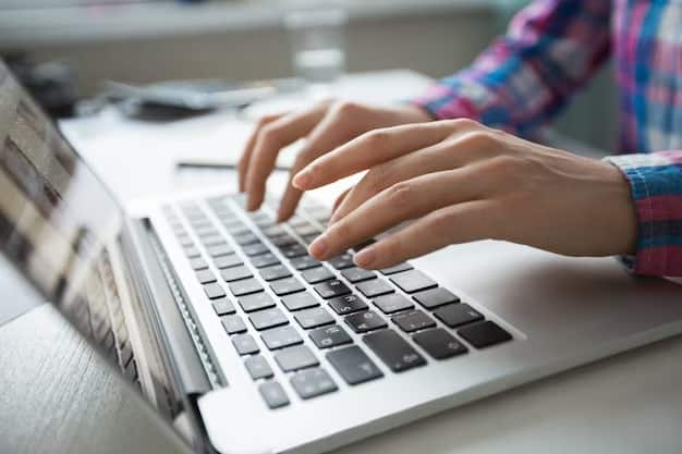 Een half gesloten laptop staat op een bureau